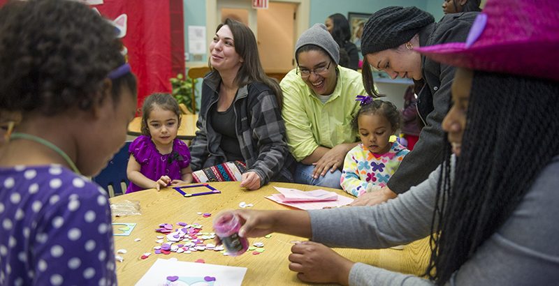 Families and children working on a craft project together at a District 4 family night